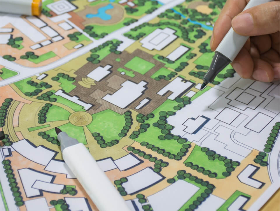 A hand draws on an illustrated map