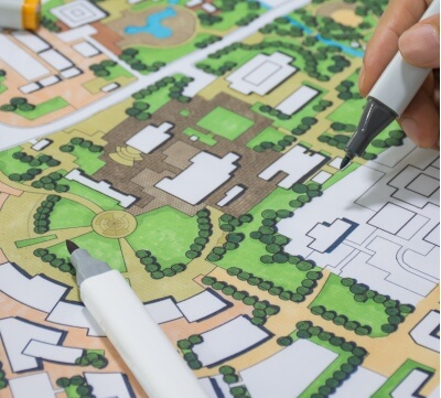 A hand draws on an illustrated map